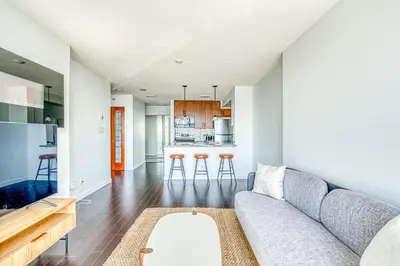 a living room with a couch and a kitchen at Central City Location, Bay View, One Free Parking in Vancouver