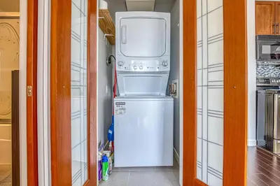 a refrigerator and a washer and dryer in a room at Central City Location, Bay View, One Free Parking in Vancouver