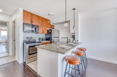a kitchen with a counter and two bar stools at Central City Location, Bay View, One Free Parking in Vancouver