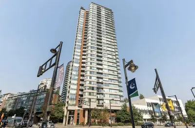 a tall building in a city with flags in front of it at Central City Location, Bay View, One Free Parking in Vancouver