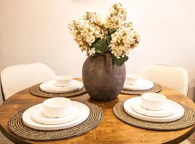 a table with plates and a vase with flowers on it at Luxury Spring Creek Condo with Hot Tub in Canmore