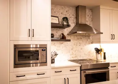 a kitchen with white cabinets and a microwave at Luxury Spring Creek Condo with Hot Tub in Canmore
