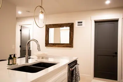 a kitchen with a sink and a mirror at Luxury Spring Creek Condo with Hot Tub in Canmore