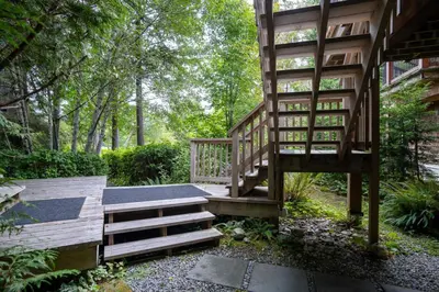 a wooden staircase leading up to a house at South Swell Tofino (formerly Blue Heron Waterfront Home amid Old Growth Cedars) in Tofino