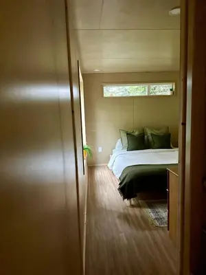 a bed in a small room with a window at Riverside Retreat in Cowichan Bay
