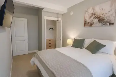 a bedroom with a large white bed with green pillows at Bright & Modern 1-Bedroom Guest Suite in Chilliwack