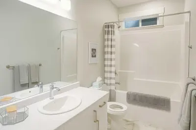 a white bathroom with a sink and a toilet at Bright & Modern 1-Bedroom Guest Suite in Chilliwack