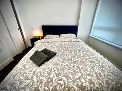 a bedroom with a bed with a black purse on it at Mordern stylish 2B2B close to Richmond center in Richmond