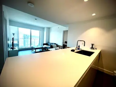 a kitchen with a sink and a living room at Mordern stylish 2B2B close to Richmond center in Richmond
