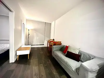 a living room with a couch and a large window at Cozy and convenient 1B1B near Richmond center in Richmond