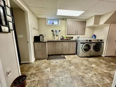 a kitchen with a washer and dryer in it at Beautiful Suite Fenced yard Kitchen Laundry in St. Albert