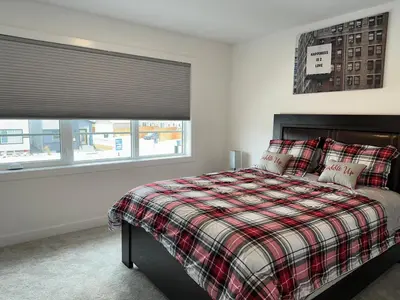a bedroom with a bed and a window at Modern new townhouse in Red Deer
