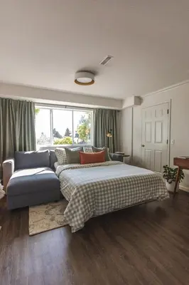 a bedroom with a large bed and a couch at Modern Lynn Valley Retreat with Mountain and City Views in North Vancouver