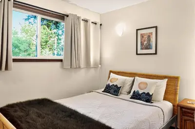 a bedroom with a bed and a window at Little Bear Cabin at Raven's Moon in Ucluelet