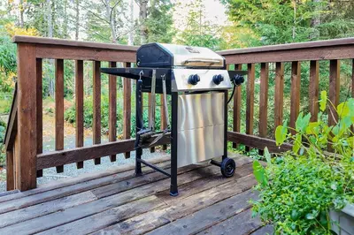 a barbecue grill sitting on a wooden deck at Little Bear Cabin at Raven's Moon in Ucluelet