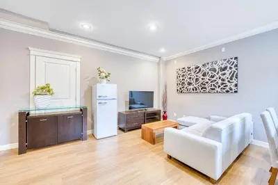 a living room with a white couch and a tv at Cozy two beds lower level suite in Vancouver West in Vancouver