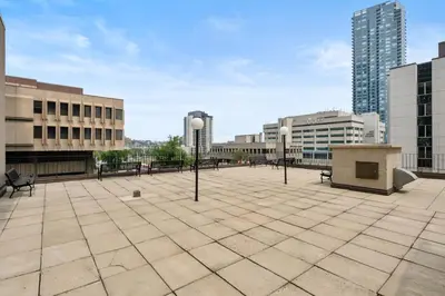a large plaza with benches and street lights in a city at Central Downtown at Rocky Mountain Court with Gym, Court, Sauna and Secured Parking in Calgary