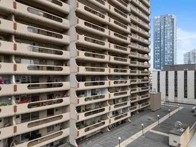 an apartment building with balconies on a city street at Central Downtown at Rocky Mountain Court with Gym, Court, Sauna and Secured Parking in Calgary