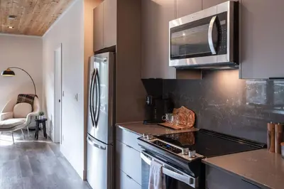 a kitchen with a stove and a refrigerator at The Begbie Penthouse in Mackenzie Village in Revelstoke