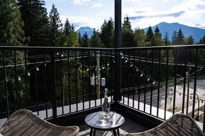a balcony with two chairs and a table with a view at The Begbie Penthouse in Mackenzie Village in Revelstoke