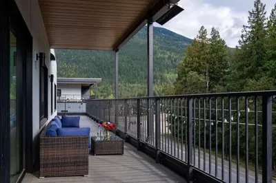 a balcony with a blue couch and a view of the mountains at The Begbie Penthouse in Mackenzie Village in Revelstoke