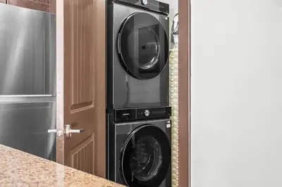 a washer and dryer in a kitchen next to a door at Bears Den 2BR Getaway with Hot Tub, BBQ Near DT in Dead Man's Flats