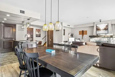 a kitchen and living room with a table and chairs at Bears Den 2BR Getaway with Hot Tub, BBQ Near DT in Dead Man's Flats