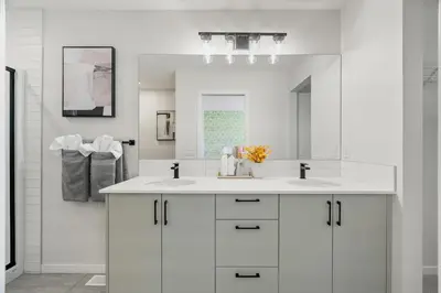a white bathroom with two sinks and a mirror at Brand New Cozy2BR House NW Calgary DT Banff Sleep4 in Calgary