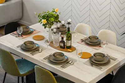 a white table with plates and wine bottles on it at Brand New Cozy2BR House NW Calgary DT Banff Sleep4 in Calgary