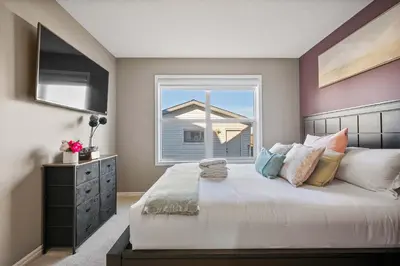 a bedroom with a large bed with a window at Large Family Home w Kid's Play Tent! FREE Banff Pass in Calgary