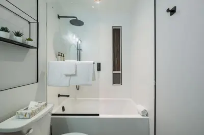 a white bathroom with a tub and a toilet at Symphony 8 by Outpost Whistler in Whistler