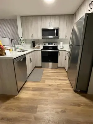 a kitchen with stainless steel appliances and wooden cabinets at The SuiteLife, Calgary in Calgary