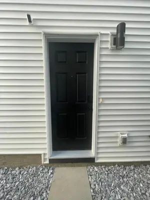 a black door on the side of a house at The SuiteLife, Calgary in Calgary