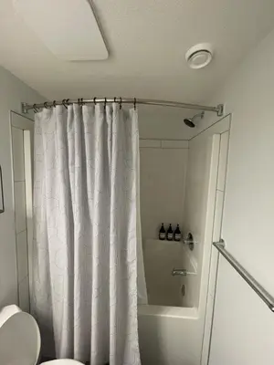 a bathroom with a shower curtain and a toilet at The SuiteLife, Calgary in Calgary