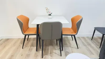 a table with four chairs and a white table with a vase on it at Northern Nook - 2BR Suite in Calgary