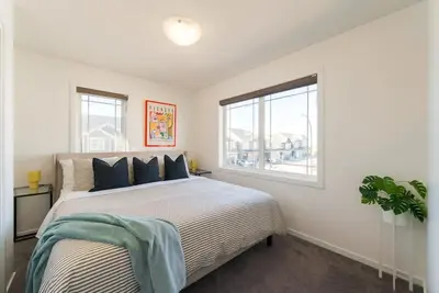 a bedroom with a large bed and a window at Spacious Suite in Calgary