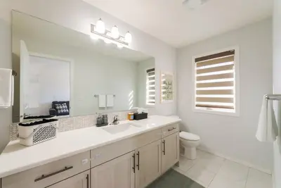 a white bathroom with a sink and a toilet at Spacious Suite in Calgary