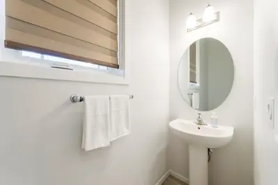 a white bathroom with a sink and a mirror at Spacious Suite in Calgary