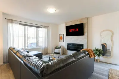 a living room with a leather couch and a television at Spacious Suite in Calgary