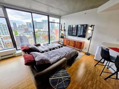 a living room with a couch and a large window at Historic Downtown Escape in Vancouver