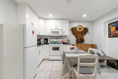 a kitchen with a table and a white refrigerator at Spacious 3BR with Full Kitchen a n dFast Wi-Fi in Vancouver
