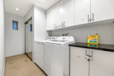 a kitchen with white cabinets and a washer and dryer at Spacious 3BR with Full Kitchen a n dFast Wi-Fi in Vancouver