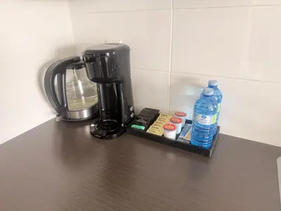 a coffee maker and a bottle of water on a counter at Mollies Alpha in Langford