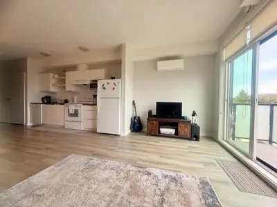 an empty living room with a refrigerator and a tv at Mollies Alpha in Langford
