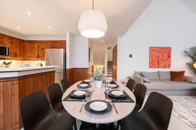 a kitchen and living room with a table and chairs at Blackcomb Greens 33 by Outpost Whistler in Whistler