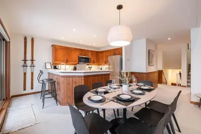 a kitchen and dining room with a table and chairs at Blackcomb Greens 33 by Outpost Whistler in Whistler