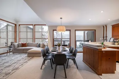 a kitchen and living room with a table and chairs at Blackcomb Greens 33 by Outpost Whistler in Whistler