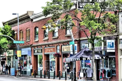 a red brick building on a city street with a store at Cozy Boho Studio Suite in Calgary