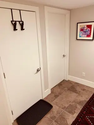 a hallway with white doors and a tile floor at Cozy Boho Studio Suite in Calgary