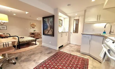 a kitchen and living room with a couch and a table at Cozy Boho Studio Suite in Calgary